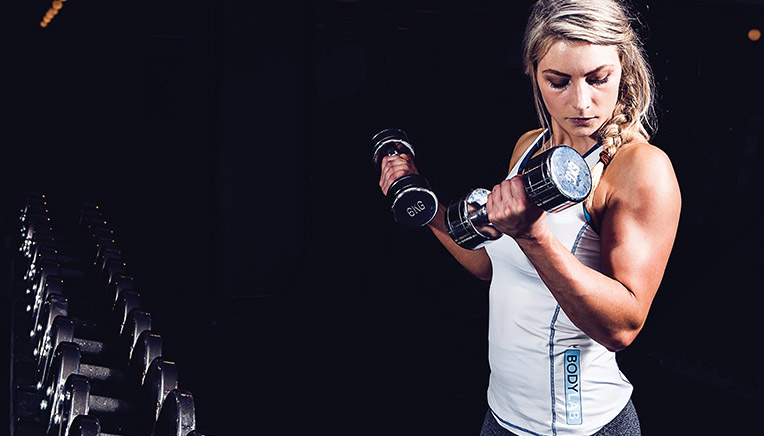 Kvinde der muskelopbygger ved styrketræning